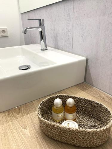 a bathroom with a sink and a basket with two jars at Winterberg Appartement 21114 in Winterberg