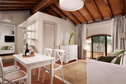 a kitchen and living room with a table and chairs at Borgo Antico Casalbosco Holiday Home & Winery in Santomato 