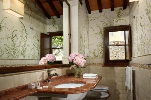 a bathroom with a sink and a toilet and a mirror at Borgo Antico Casalbosco Holiday Home & Winery in Santomato 