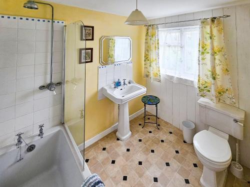 a bathroom with a sink and a tub and a toilet at Wringford Farm Annexe in Cawsand