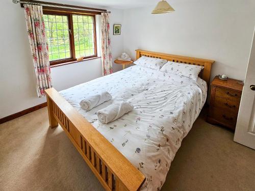 a bedroom with a bed with two pillows on it at Wringford Farm Annexe in Cawsand