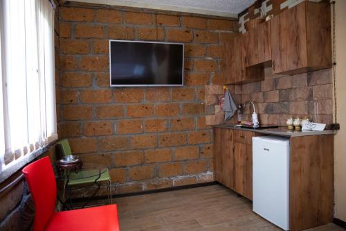 cocina con pared de ladrillo y nevera blanca en Noravank L-and-L, en Namazalu