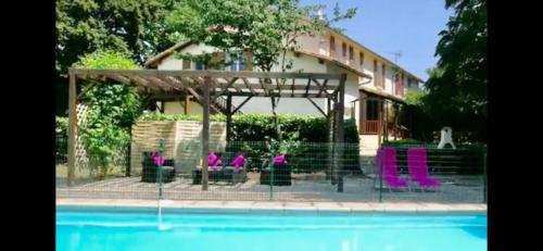 a group of purple chairs sitting next to a pool at Les Roseries Boutique Gite in Clussais-la-Pommeraie