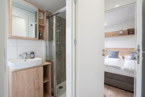 ein Bad mit einem Waschbecken und einem Bett in der Unterkunft Ostseecamp Ferienhaus "Horizont" in Scharbeutz