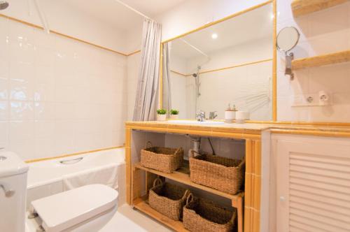 a bathroom with a sink and a toilet and a tub at Villa Asarel by Sonne Villas in Cala Galdana