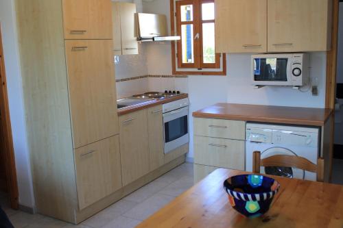 a kitchen with wooden cabinets and a table with a bowl on it at Paros Molos beachfront appartment in Kampos Paros