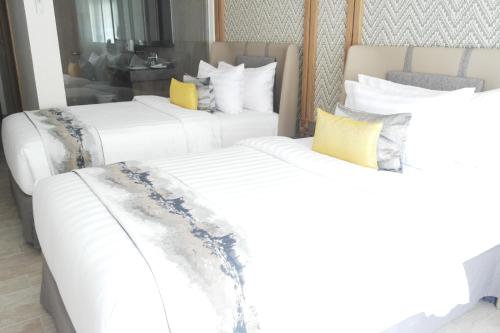 two white beds in a hotel room at Louis Kienne Resort Senggigi in Senggigi 