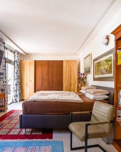 a bedroom with a large bed and a chair at Eigner Suite 100 qm - Loft mit Ausblick in Calera