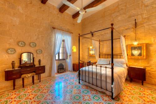 - une chambre avec un lit, un bureau et un miroir dans l'établissement Dar il-Wied Farmhouse, à L-Għarb