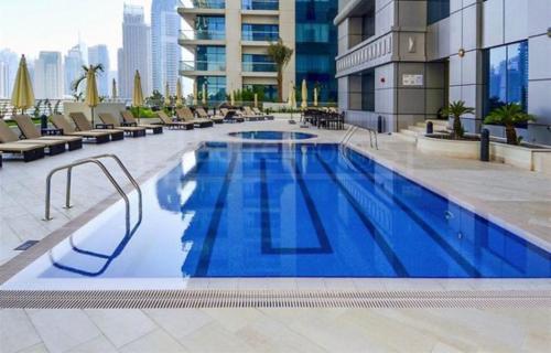 a large swimming pool with chairs and a building at The Mood House I Dubai Marina in Dubai