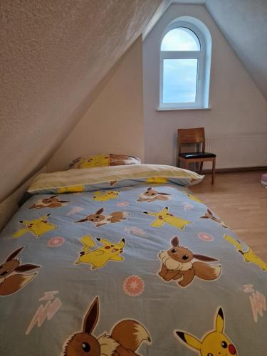 Una cama con un edredón con animales. en Pension im Grünen 