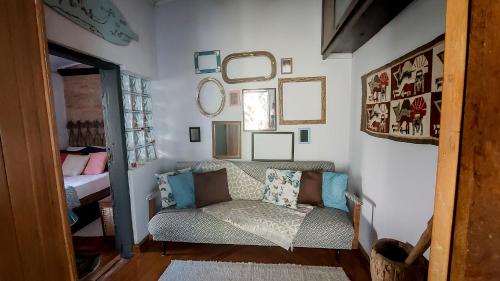 a living room with a couch and mirrors on the wall at Suítes em casa centenária no centro de Socorro in Socorro