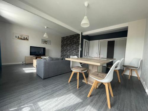 uma sala de estar com uma mesa e cadeiras e um sofá em Appart lumineux au calme 2 ou 3 pers em Chalon-sur-Saône