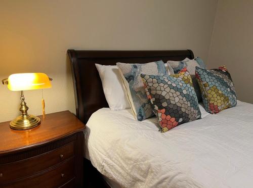 a bed with pillows and a lamp on a night stand at Palo Alto Quiet 1 Bedroom Stanford University in Palo Alto