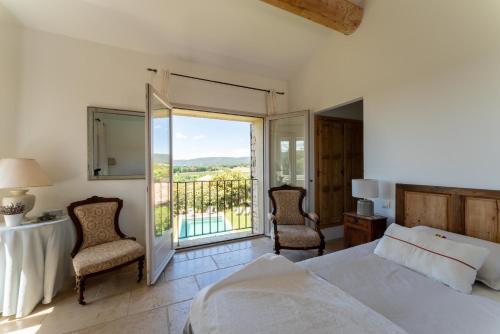 ein Schlafzimmer mit einem Bett und einem Balkon in der Unterkunft Villa Les Terrasses de Gordes in Gordes