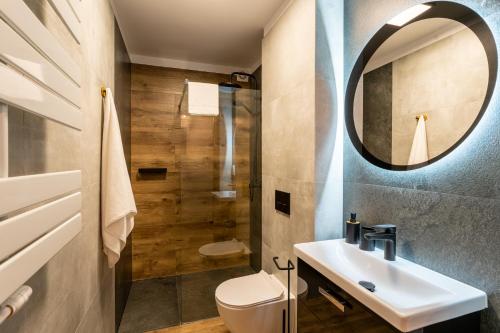 a bathroom with a sink and a toilet and a mirror at Villa Sol in Oświęcim