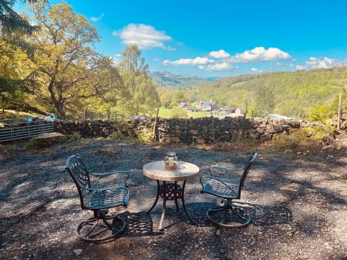 two chairs and a table with a tea kettle on it at Romantic Shepherd Hut with Optional Hot Tub in Snowdonia in Dolgellau