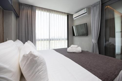 a bedroom with a large bed with white pillows at Tropics Kamala Deluxe Pool View Apartment CTG P402 in Kamala Beach