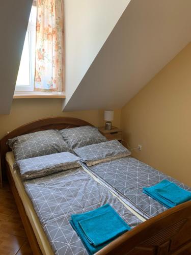 Ce lit se trouve dans un dortoir doté d'oreillers bleus. dans l'établissement Apartament Iwona, à Mrągowo