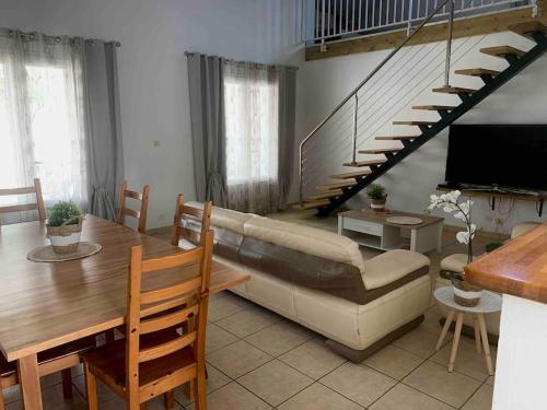 - un salon avec un canapé, une table et des escaliers dans l'établissement Villa Fleurs de Cannes 4*, à Saint-Louis