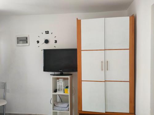 ein Wohnzimmer mit einem TV und einem weißen Schrank in der Unterkunft Casa Alba 2 in Puerto del Rosario