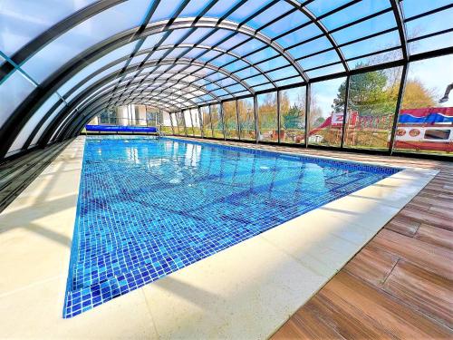 an indoor swimming pool with a glass ceiling at Apartament VIP Sztutolo z basenem in Sztutowo