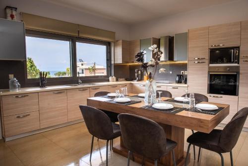 a kitchen with a large wooden table and chairs at Odyssea Sea View Apartment one minute from the sea in Kremasti