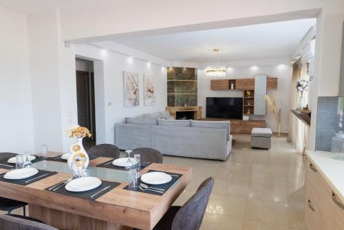 a dining room and living room with a table and chairs at Odyssea Seaside Apartment with Sea View and Pool in Kremasti