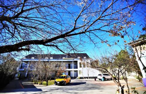 a yellow car parked in front of a building at Junyi Landscape Villa in Renai