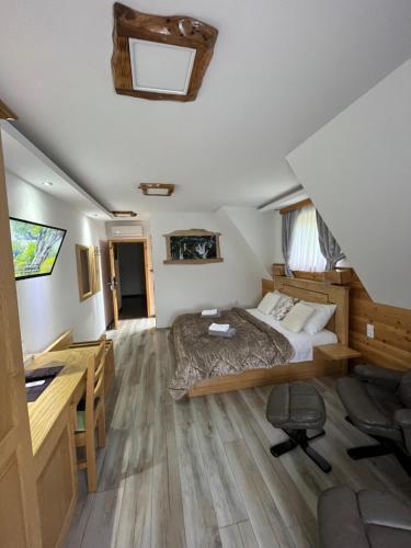 a bedroom with a bed and a desk in a room at Rustic Inn River in Plitvička Jezera
