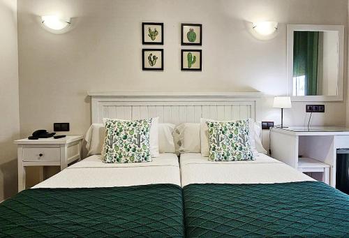 1 dormitorio con 1 cama verde y blanca con 2 almohadas en Hotel Medina de Toledo, en Toledo