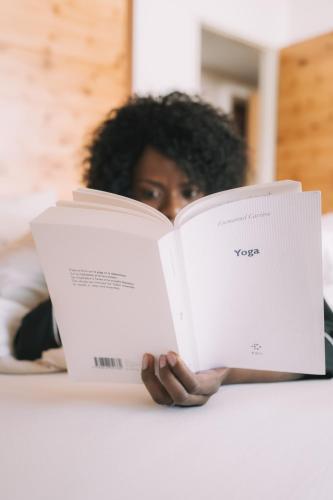 a woman is reading a book at a table at Hotel Enzian - Adults Only in Obertauern