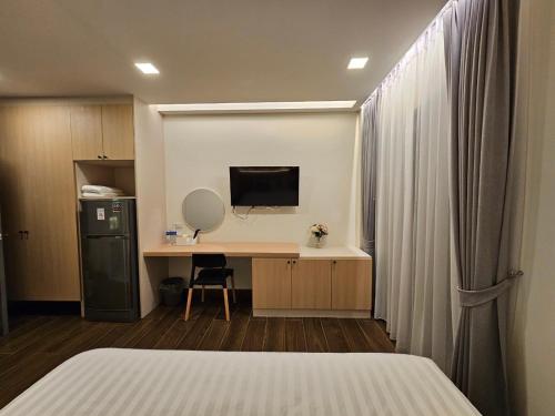 a bedroom with a bed and a desk with a television at บ้านสุขใจ สามใบเถา in Ban Kluai