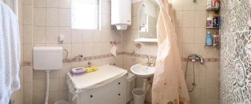 ein Badezimmer mit einem Waschbecken, einem WC und einem Spiegel in der Unterkunft Holiday home - Bogi 1 in Belgrad