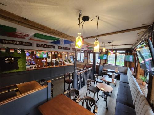 a restaurant with tables and chairs and a bar at Newcastle House Rothbury in Rothbury
