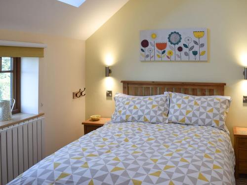 1 dormitorio con 1 cama y una pintura en la pared en The Granary, en North Kilvington