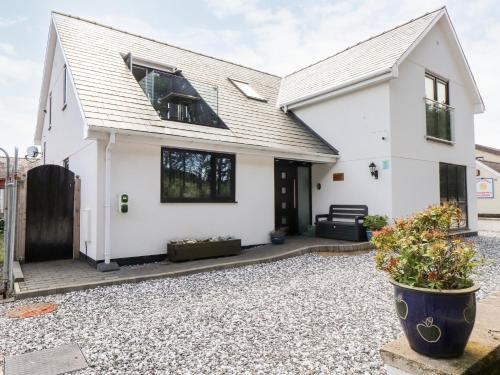 a white house with a gravel driveway at Seagull Shack in Porthmadog