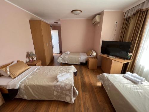 a hotel room with two beds and a flat screen tv at Motel restoran Sunce in Sremska Kamenica