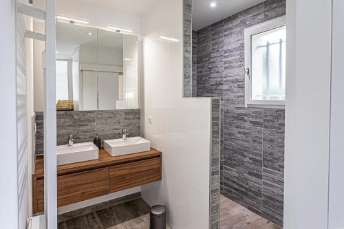 une salle de bain avec deux lavabos et un miroir dans l'établissement Emachethaco - Location vacances hossegor superbe villa de standing avec jardin et piscine chauffée, à Soorts-Hossegor