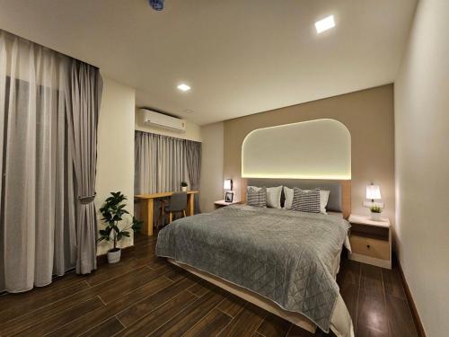 a bedroom with a large bed and a large window at บ้านสุขใจ สามใบเถา in Ban Kluai