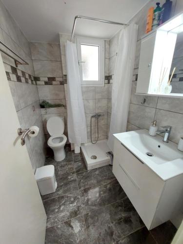 een badkamer met een toilet en een wastafel bij Crystal Home near Airport in Artemida