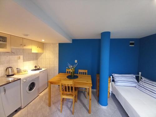 a small kitchen with a table and a blue wall at Villa Almond near Omis, private pool in Tugare