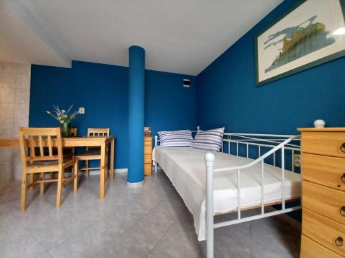 a bedroom with a bed and a table and a blue wall at Villa Almond near Omis, private pool in Tugare