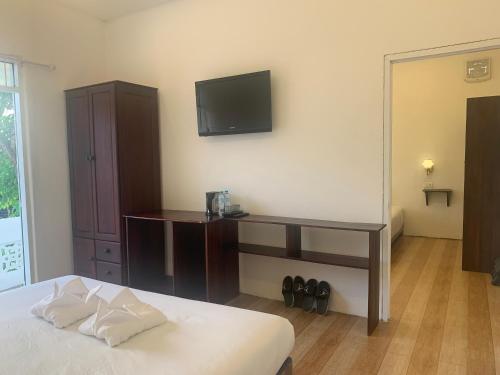 a bedroom with a bed and a tv on the wall at La nuit de laos in Luang Prabang