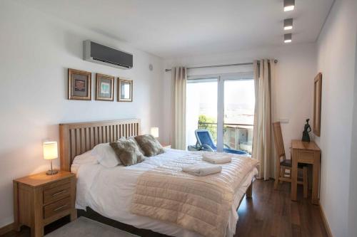 um quarto com uma cama grande e uma janela em Apartamento SUNSET T3 em São Martinho do Porto