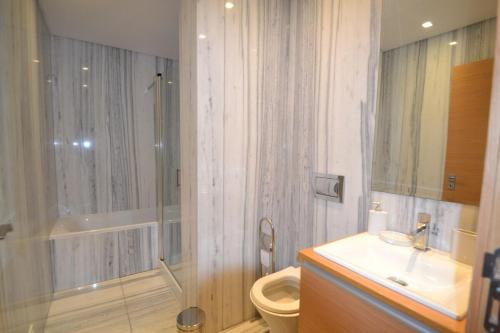 uma casa de banho com um chuveiro, um WC e um lavatório. em Apartamento SUNSET T3 em São Martinho do Porto