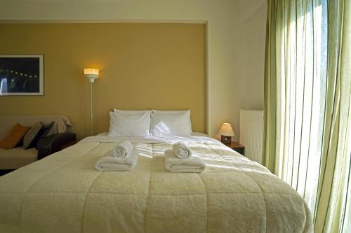 a hotel room with a bed with towels on it at SEMIRAMIS SUITES with pool in Kalamata