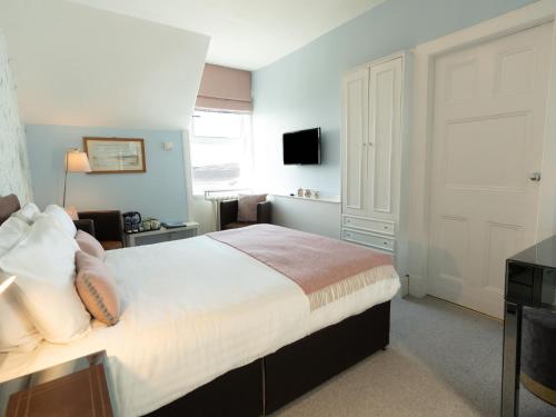 a bedroom with a large bed and a television at Loch Melfort Hotel in Ardfern