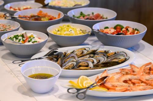 a table topped with bowls of different types of food at Melia Braga Hotel & Spa in Braga