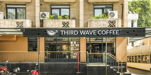 a building with a third wave coffee sign on it at The Legend Inn Delhi in New Delhi